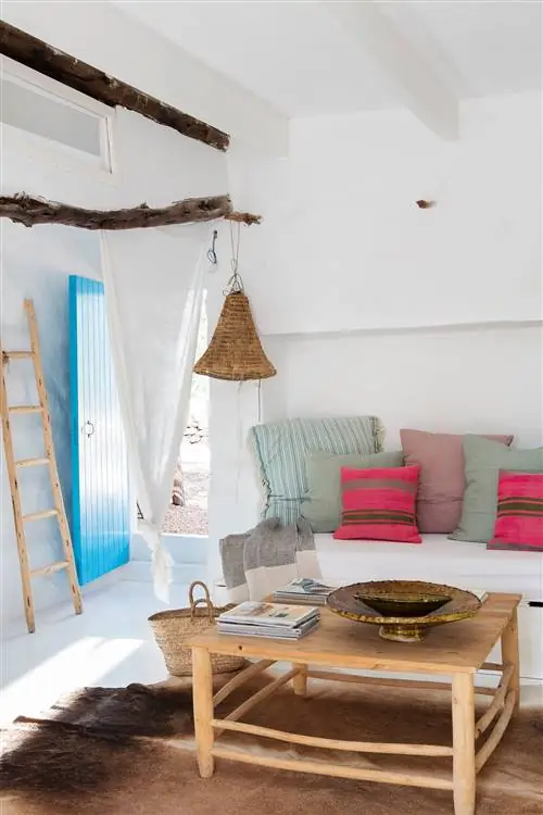 Средиземноморская гостиная с белой встроенной скамейкой и деревянным журнальным столиком