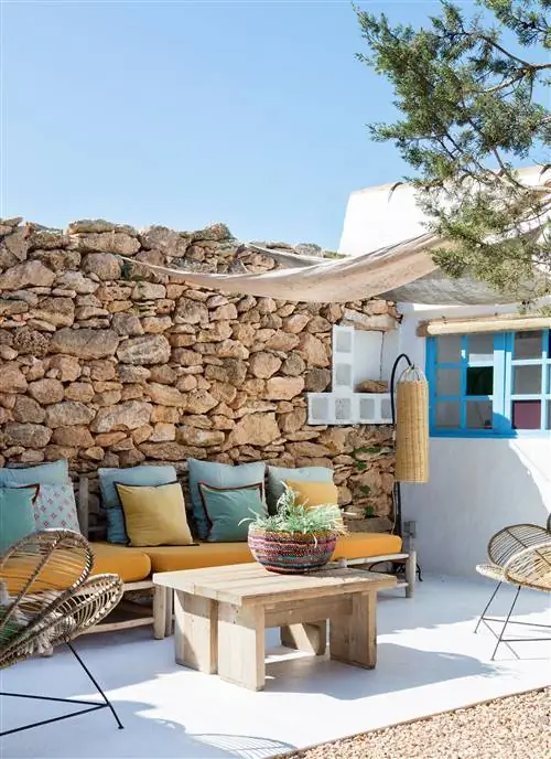 терраса со скамейками из ротанга с цветными подушками