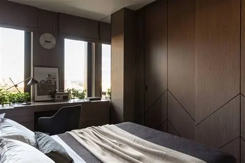 спальня с письменным столом и встроенными деревянными шкафами