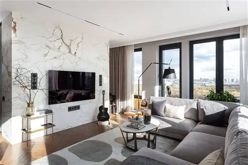 современная гостиная с серым угловым диваном и мраморными покрытиями