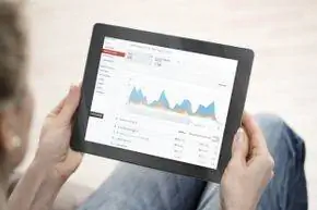 Человек просматривает YouTube Analytics на планшете.
