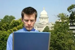 Парень смотрит на ноутбук на фоне Капитолия