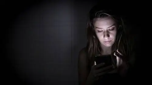 женщина пишет смс по телефону