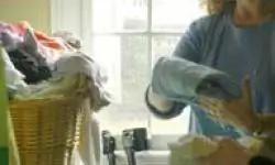 женщина с костылями складывает белье