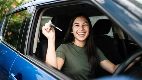 Женщина с ключами в руке гордится тем, что получила новую машину.