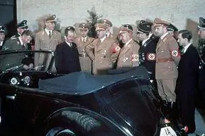 Адольф Гитлер и другие нацистские чиновники восхищаются подарком Гитлера на 50-летие - кабриолетом Volkswagen. Адольф Гитлер и другие нацистские чиновники восхищаются подарком Гитлера на 50-летие - кабриолетом Volkswagen.