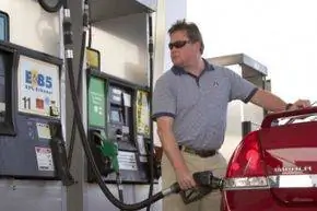 мужчина заправляет машину бензином E85
