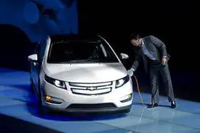 Сотрудник GM China заряжает Chevrolet Volt во время церемонии отправки пары Volt в Шанхайское выставочное бюро в Шанхае, Китай.