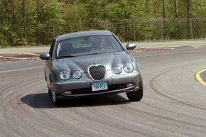 Водитель-испытатель водит седан Jaguar по испытательному треку компании в Ист-Хаддаме, штат Коннектикут.