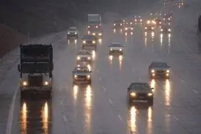 Фары отражаются на скользкой от дождя автостраде во время шторма в Инглвуде, Калифорния.
