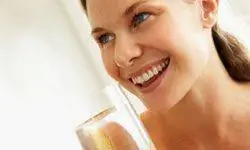 Молодая женщина пьет стакан воды Молодая женщина пьет стакан воды