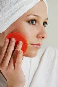 Женщина с отшелушивающей подушечкой на лице.