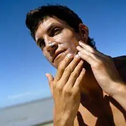 мужчина с солнцезащитным кремом