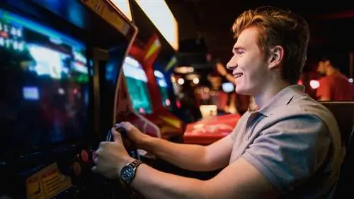 Молодой человек играет в игровые автоматы.