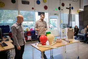 Два члена команды Google X демонстрируют круглую антенну и блочный пакет для Google Loon, экспериментального интернет-провайдера на основе воздушного шара. Два члена команды Google X демонстрируют круглую антенну и блочный пакет для Google Loon, экспериментального интернет-провайдера на основе воздушного шара.