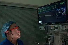 Врач в Google Glass смотрит на экран жизненно важных органов пациента. Врач в Google Glass смотрит на экран жизненно важных органов пациента.