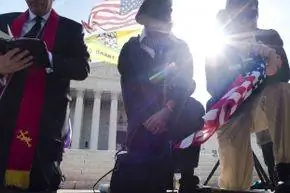 Демонстранты молятся возле Верховного суда США на третий день устных прений по поводу конституционности Закона о защите пациентов и доступном медицинском обслуживании 28 марта 2012 года.