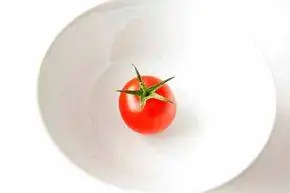 помидор на тарелке