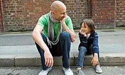 отец и сын сидят на обочине