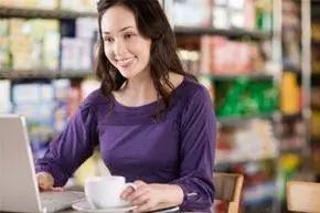 молодая женщина за ноутбуком в кафе