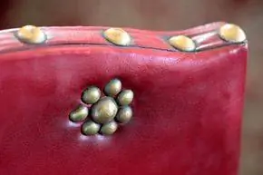 латунные шпильки на старинном красном стуле латунные шпильки на старинном красном стуле
