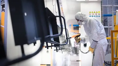 Изображение человека, распыляющего порошковую краску.