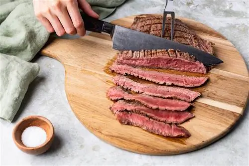 человек режет приготовленный стейк из фланга кухонным ножом человек режет приготовленный стейк из фланга кухонным ножом