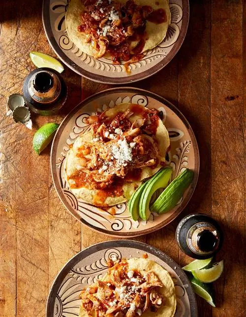 Цыпленок Тинга на декоративных тарелках с ломтиками лайма и авокадо