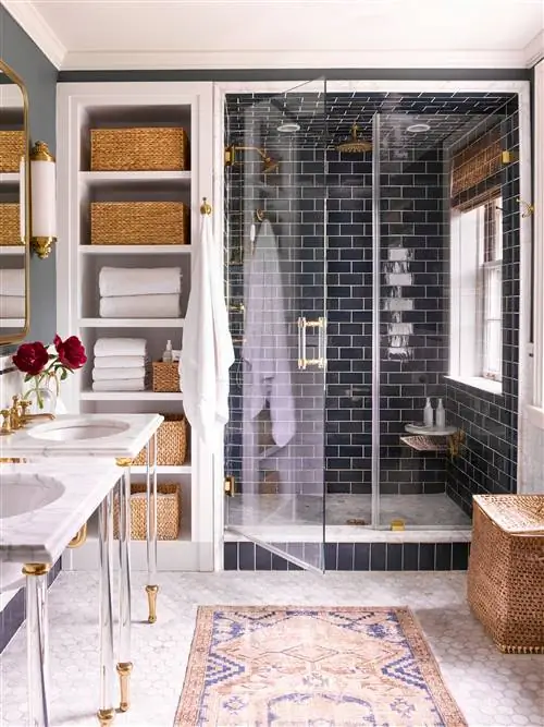 главная ванная комната с темно-синей плиткой и мраморным душем, мраморные раковины с люцитовым основанием и восточные ковры на полу, выложенном шестиугольной плиткой