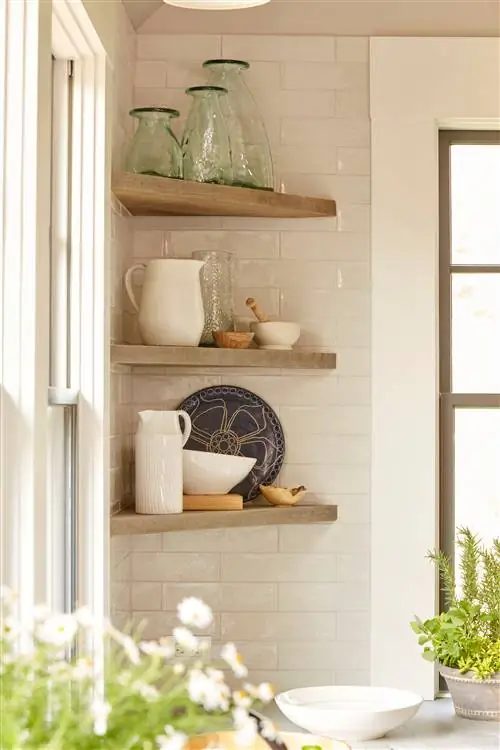 Посуда с декором на полках на стене дома