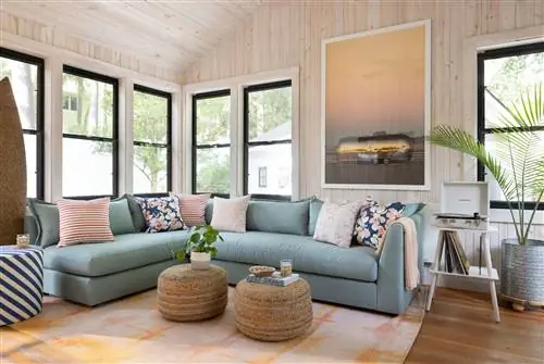 Синий секционный диван в гостиной с деревянными панелями на стенах