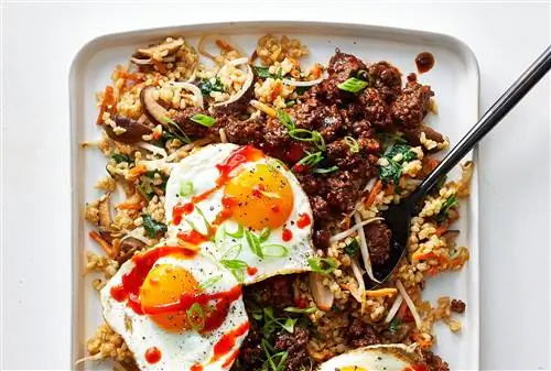 поднос с рисом и говядиной, увенчанный солнечными яйцами