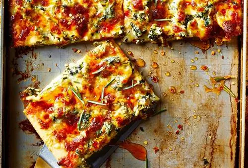 кусок бабушкиной пиццы с каплями жира на сковороде