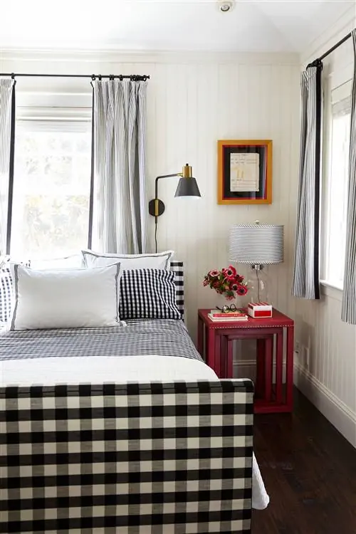 черно-белая клетчатая кровать с красным столиком и цветами