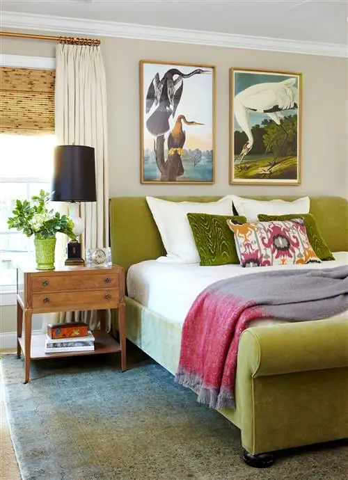 зеленовато-желтая кровать с картинами птиц на стене и розовыми акцентами