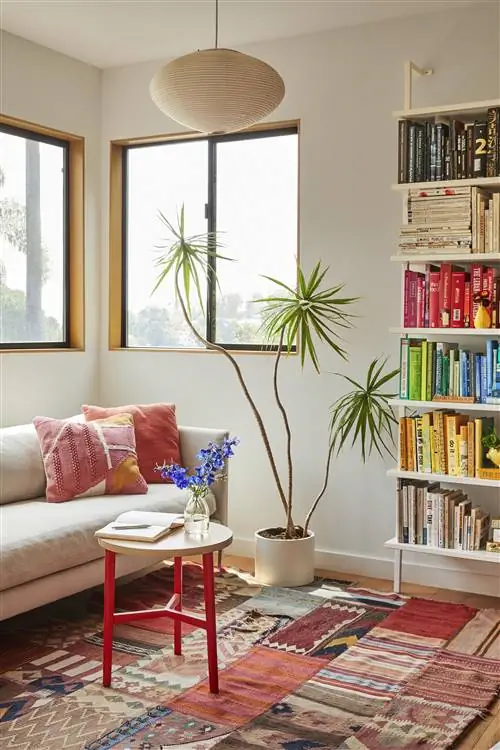 гостиная с серым диваном и книжной полкой