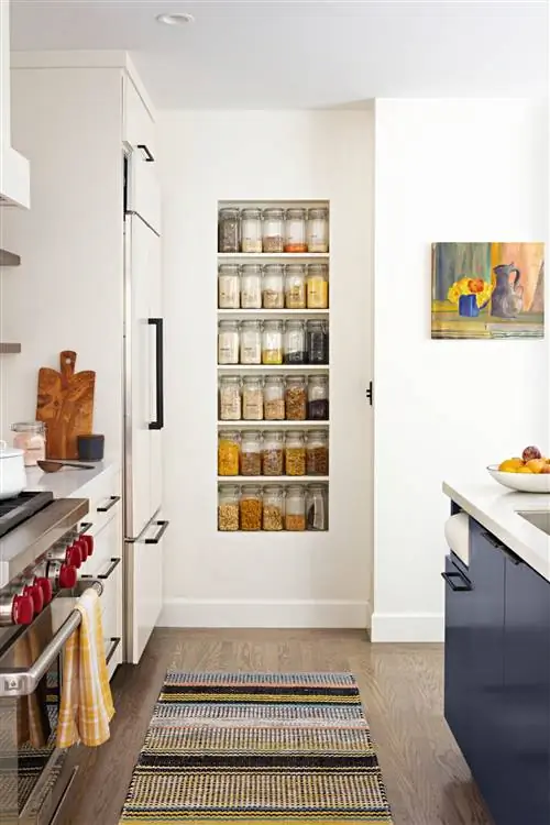 кухонная стойка для специй с синими шкафами и полосатым ковриком
