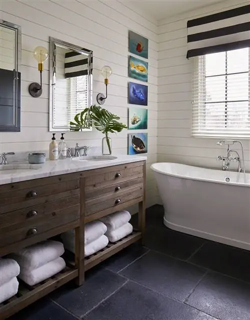 главная ванная комната с двойной раковиной и белой ванной плюс черная плитка на полу