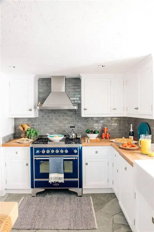 кухня с белыми шкафами и синей плитой