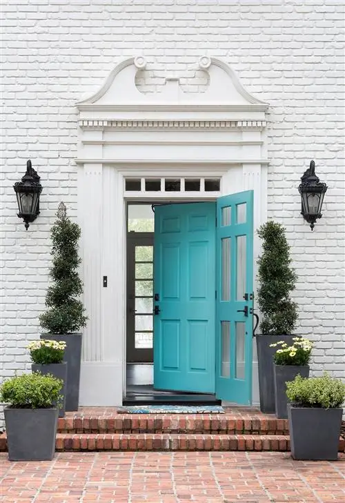 фасад из окрашенного белого кирпича с декоративной отделкой и бирюзовой входной дверью