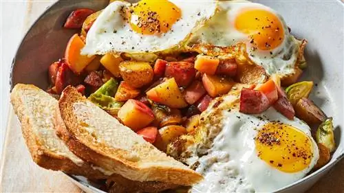 Хэш Apple-Kielbasa на сковороде с 3 яичницами и тостами