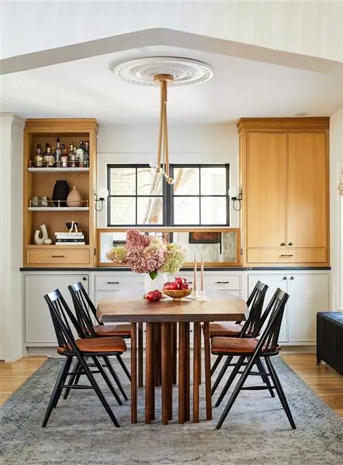 столовая с высоким потолком, серым ковром и деревянными акцентами