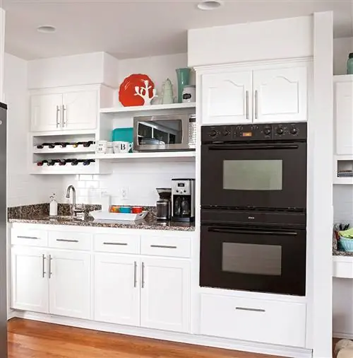 Черные многоярусные печи в белой кухне