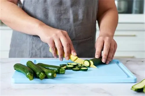 человек нарезает кабачки