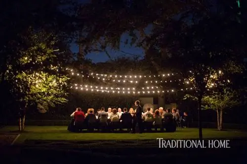 ночь снимала гостей за обеденным столом на открытом воздухе при свете фонарей