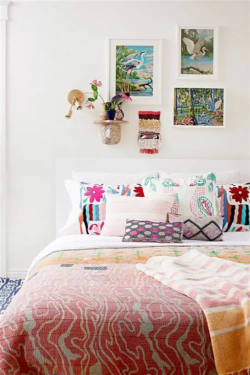 Кровать с яркими подушками и картинами на стенах
