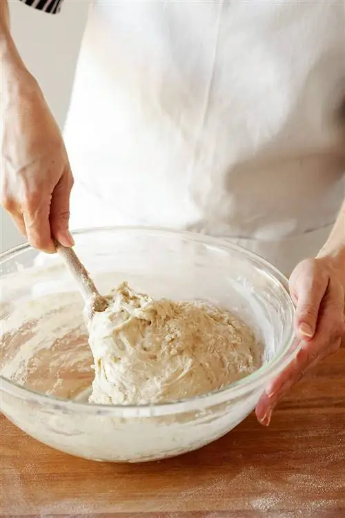 замешивание теста для хлеба деревянной ложкой