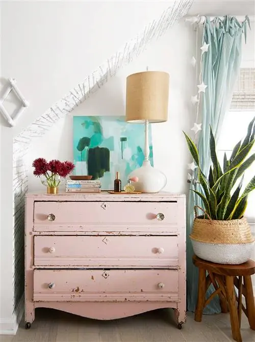 старинный окрашенный светло-розовый комод в спальне в мансарде змеиное растение