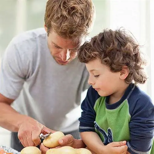 отец и сын чистят картошку