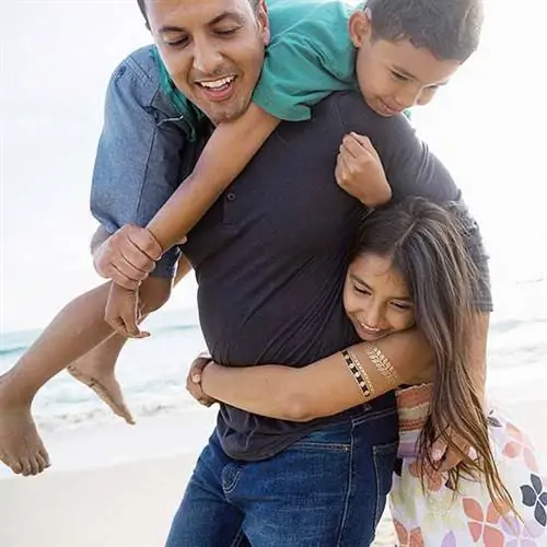 отец играет с детьми на пляже